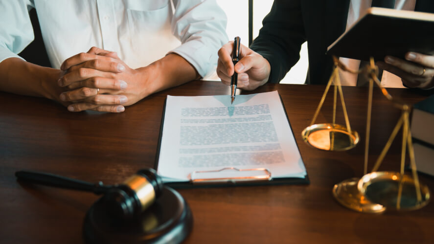 A table with paper work and a scale represents legal supports