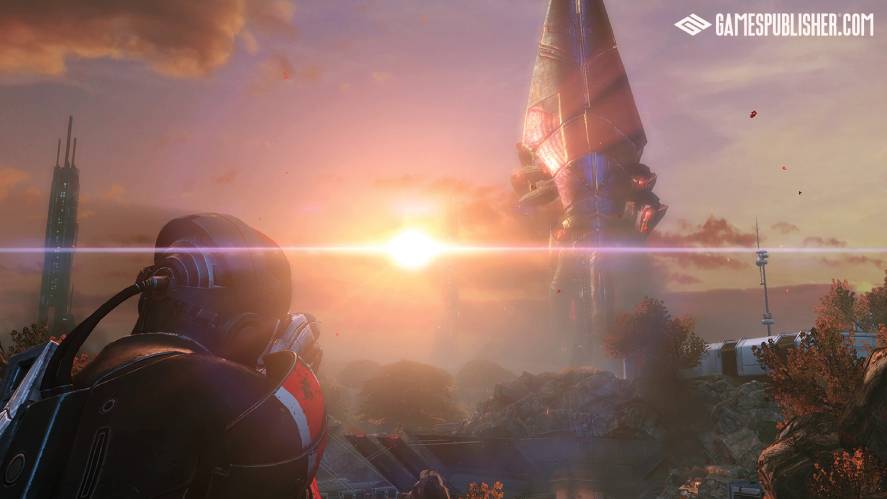An over-the-shoulder view of Commander Shepard in N7 armor aiming a weapon at a massive, towering Reaper machine against a bright, lens-flared sunset sky.
